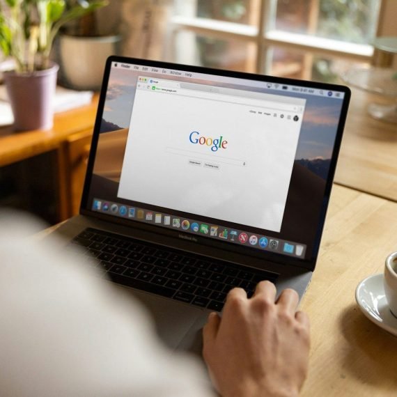 person using macbook pro on table