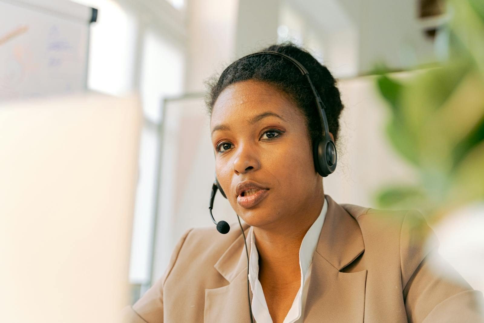 African American woman working in a call center with a headset on, providing customer support.