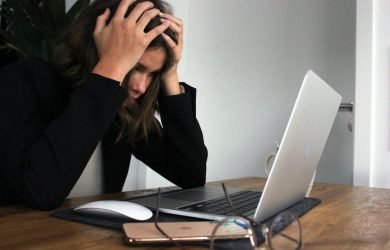 a woman sitting in front of a laptop computer